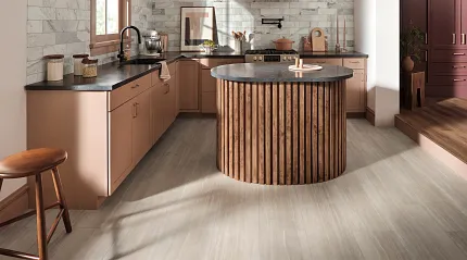 Luxury Vinyl Flooring in Modern Kitchen with Light Wood Look Modern kitchen with luxury vinyl flooring featuring a light wood look, showcasing a round wooden island and pink cabinetry