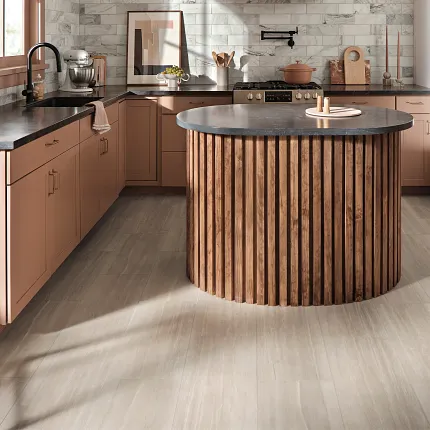 Luxury Vinyl Flooring in Modern Kitchen with Light Wood Look Modern kitchen with luxury vinyl flooring featuring a light wood look, showcasing a round wooden island and pink cabinetry
