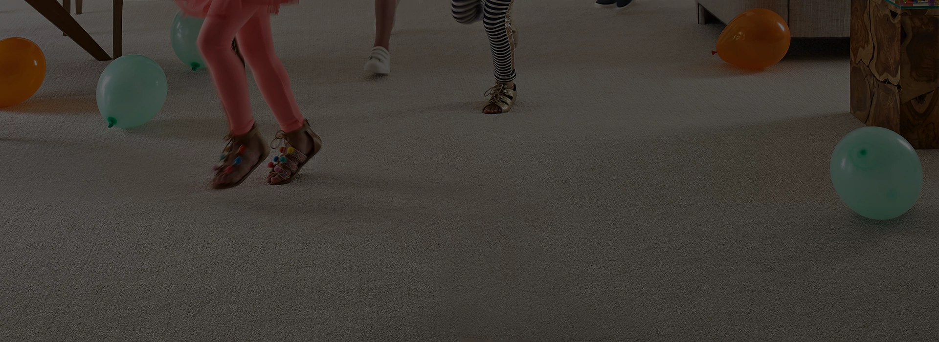 Carpeted living room with 2 kids running through