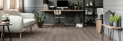 Stylish and Durable WPC Flooring for a Comfortable Home Office Modern home office with WPC flooring in a neutral tone, featuring a cozy white sofa, wooden desk, and indoor plants