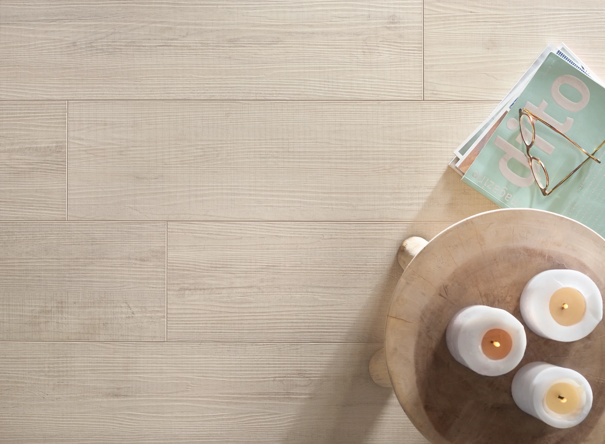 Light wood-look flooring with a natural finish, featuring a cozy setting with candles and reading glasses on a wooden table, 72.05x8.98 inch dimensions, Sound CoreÂ® construction, Direct Ship Internat