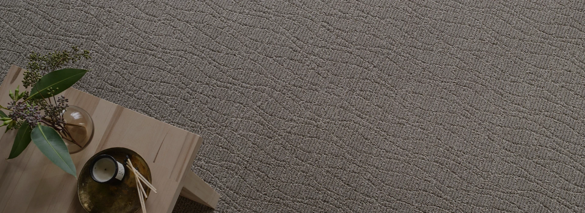 Beige textured carpet flooring with a wooden table and decorative items