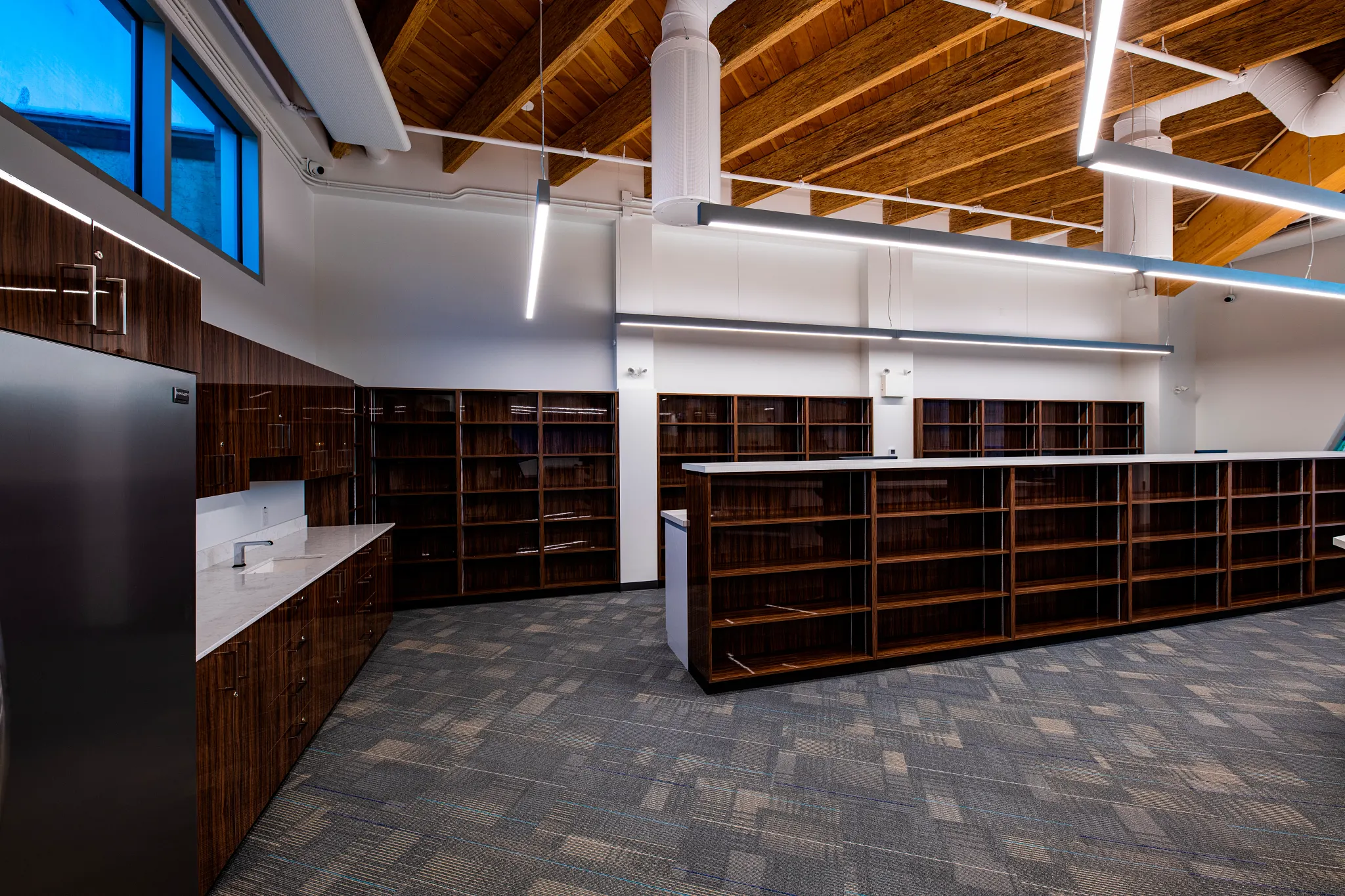 Modern retail space with wooden ceiling and commercial carpet tile flooring