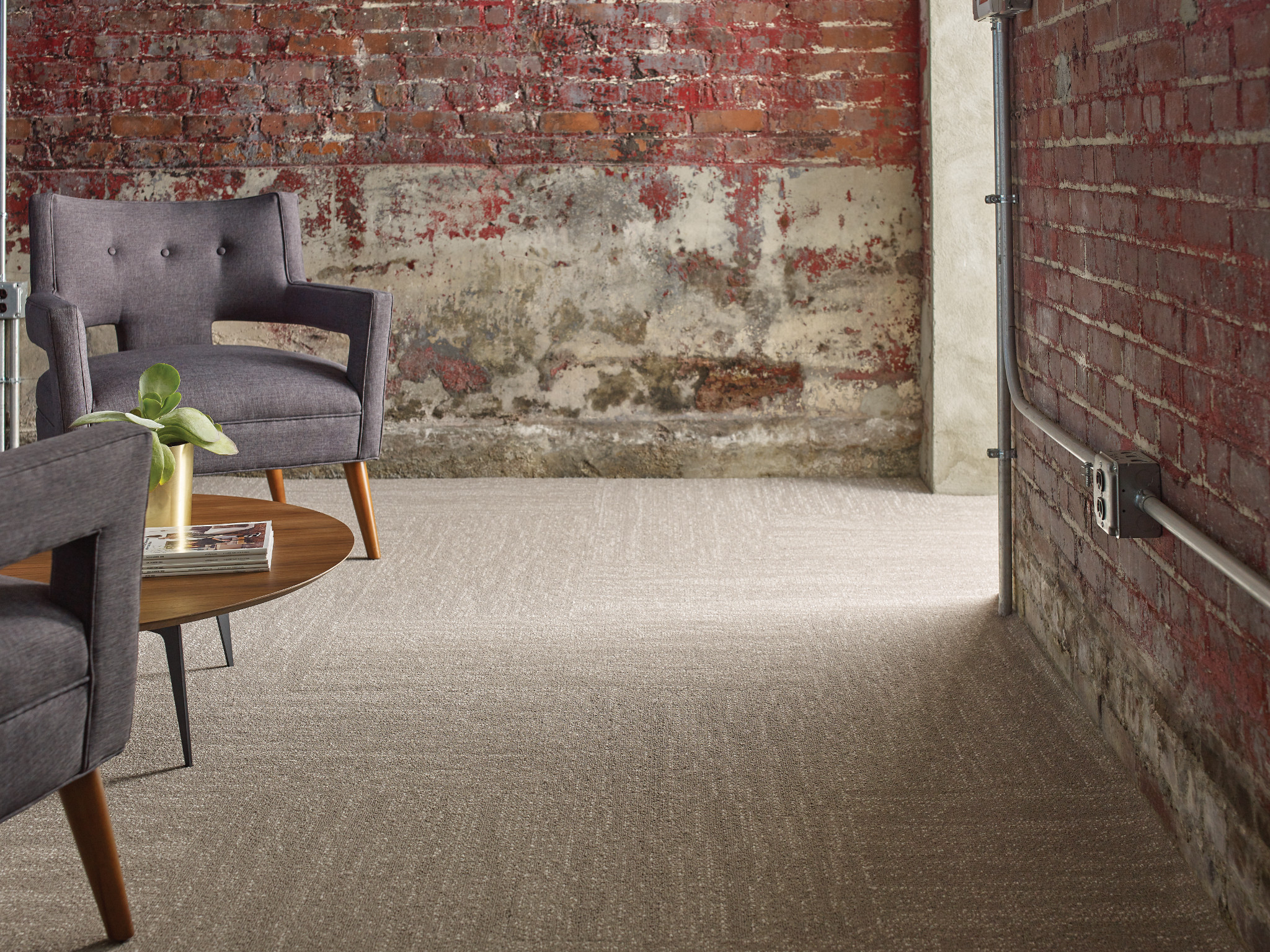 
  "Modern industrial room with exposed brick wall and beige carpet flooring"
)