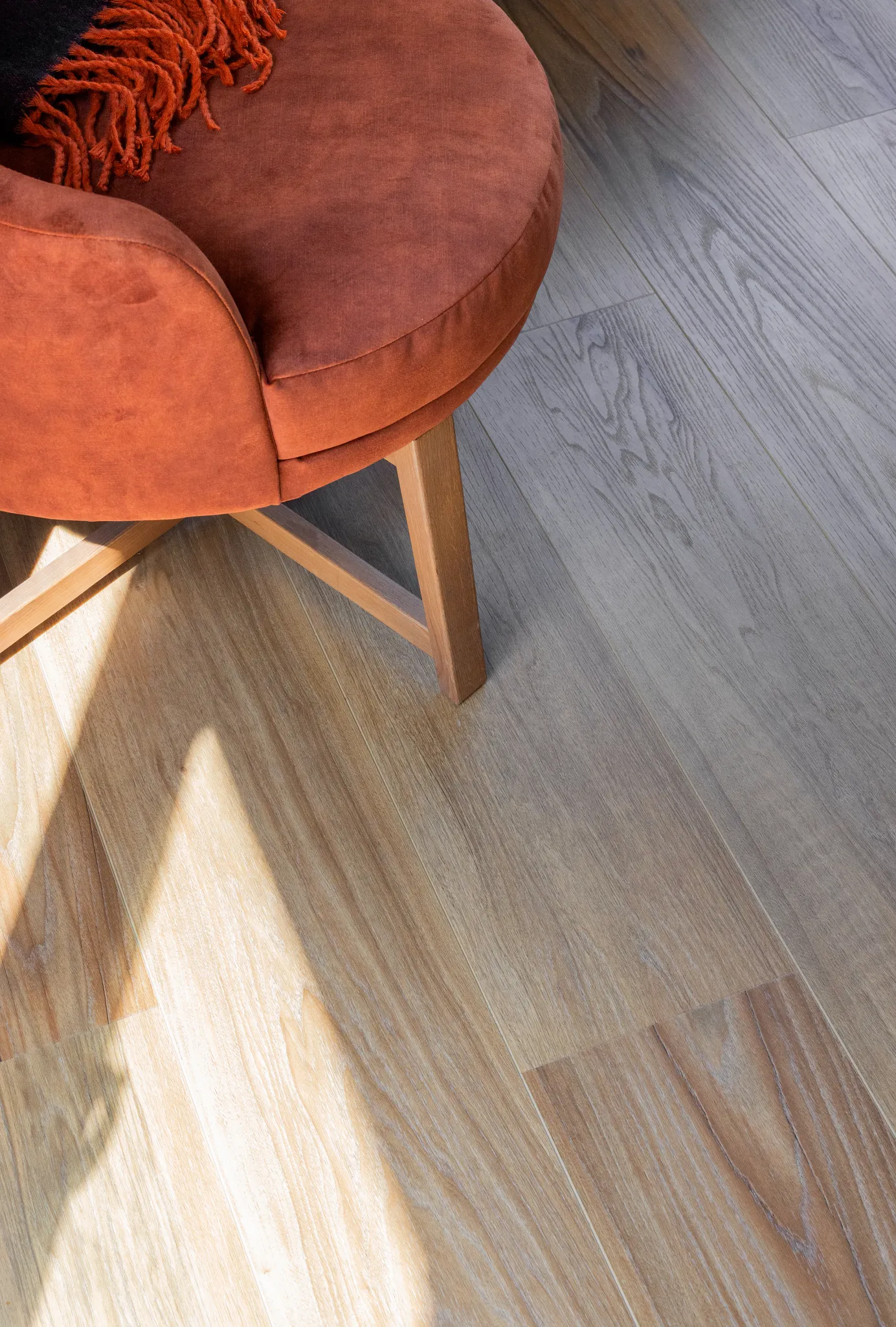 Close-up dark wooden Coretec floor with orange chair