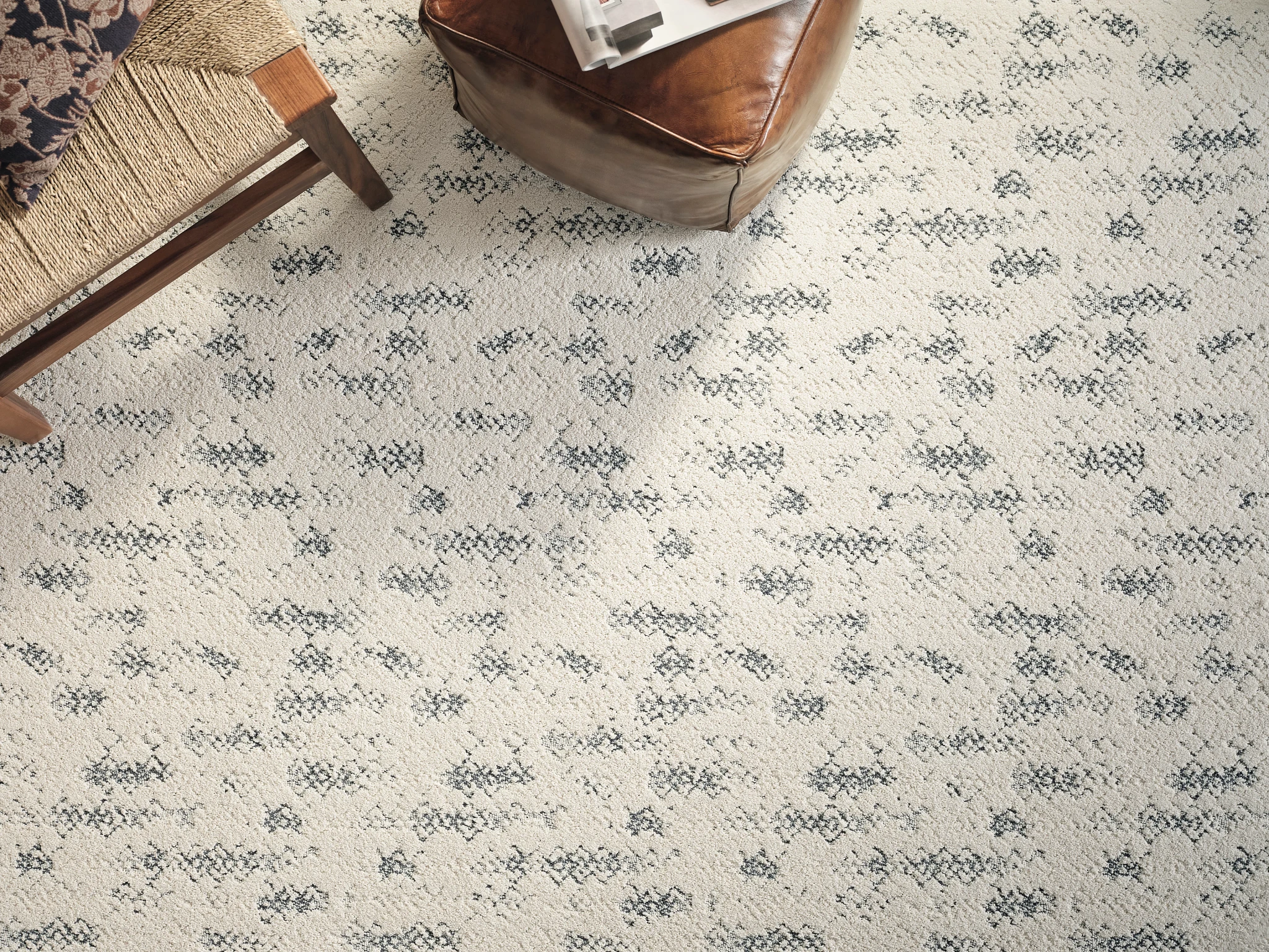 Elegant broadloom carpet in a living room setting with intricate black and gray patterns on a cream background