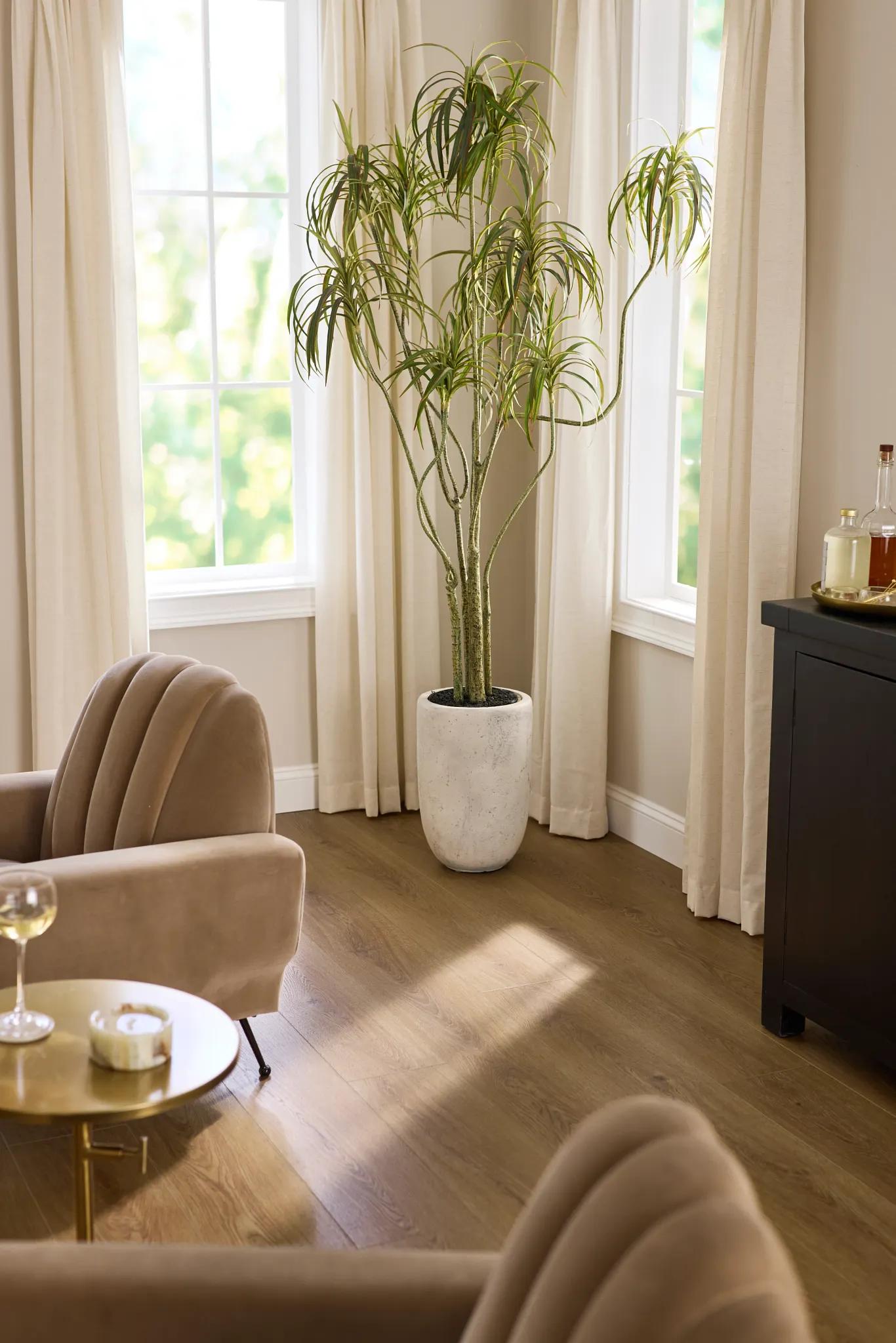 Coretec Residential WPC vinyl flooring in a cozy living room with beige armchairs and a potted plant