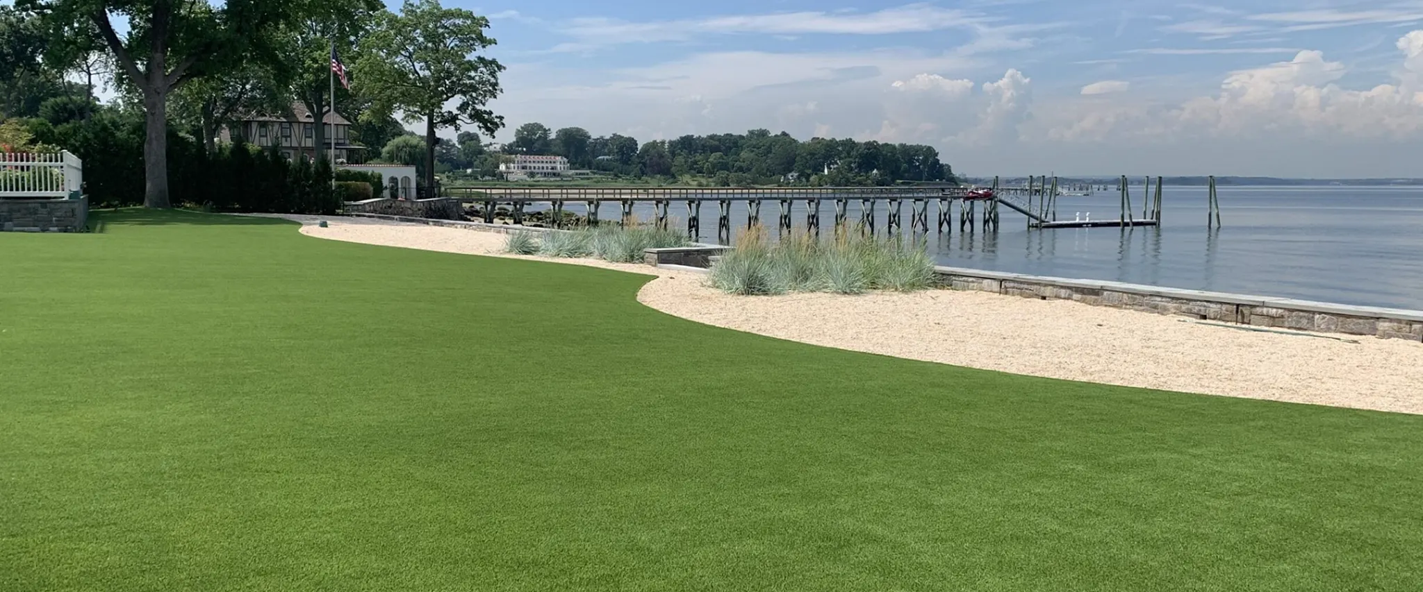 Scenic view of green lawn by the waterfront