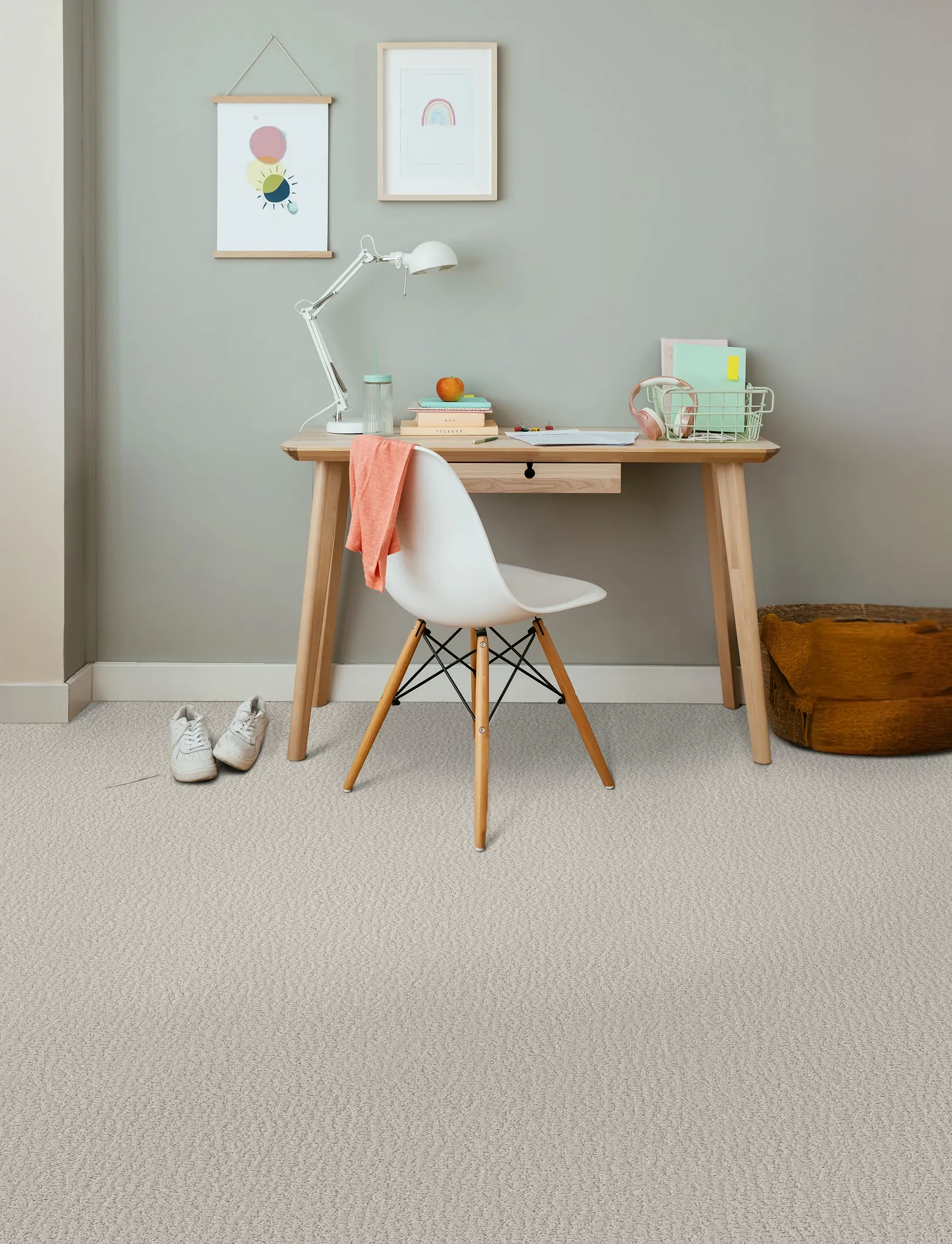 Cozy home office with patterned carpet flooring, featuring a wooden desk, white chair, and soft decor elements for a comfortable and practical lifestyle