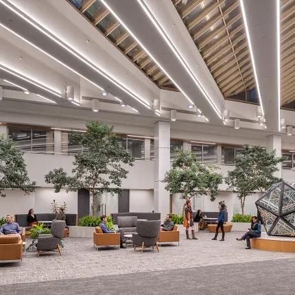 Contemporary Workplace Lobby with Commercial Carpet Flooring and Modern Design Elements Modern workplace lobby with commercial carpet flooring, featuring contemporary seating and indoor plants under a skylit ceiling