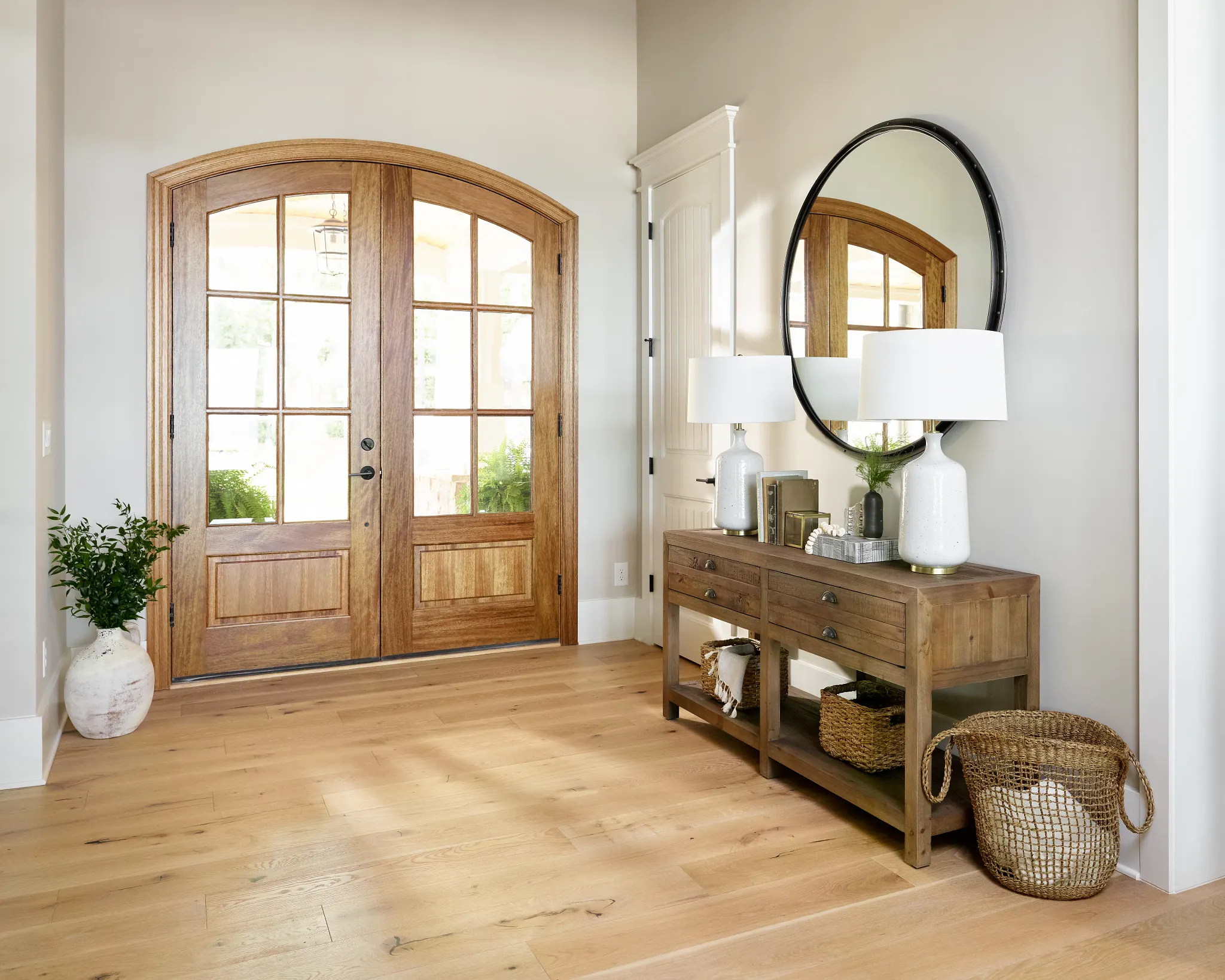 Warm and inviting entryway with light hardwood flooring, wooden console table, and decorative elements