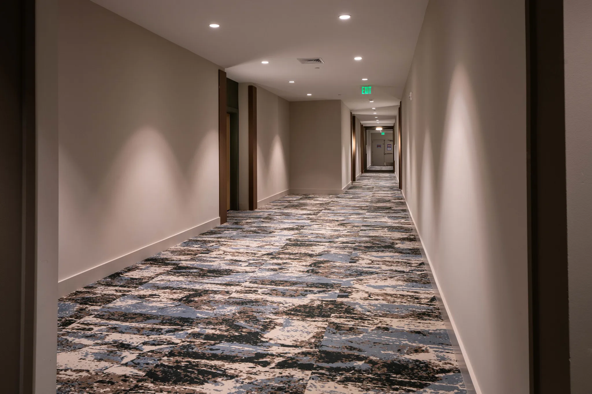 Commercial carpet tile in a hotel hallway with abstract blue and beige pattern