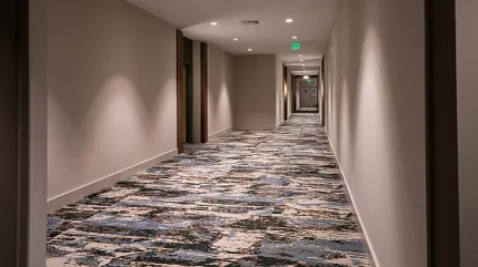 Stylish commercial carpet tile for hospitality spaces Commercial carpet tile in a hotel hallway with abstract blue and beige pattern