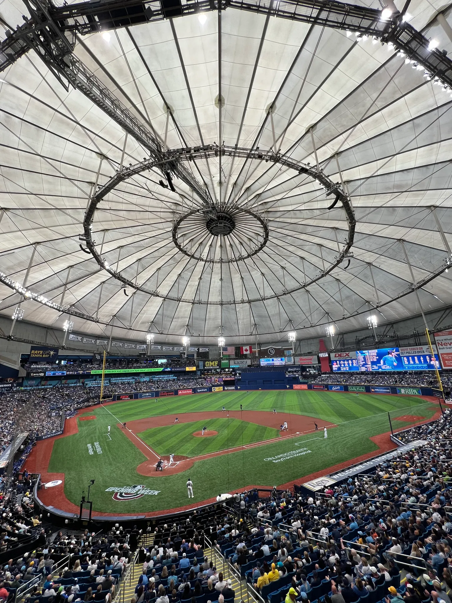 Indoor baseball stadium with artificial turf field and large crowd