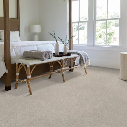 Neutral carpet flooring in a cozy bedroom setting for everyday comfort. Cozy bedroom with neutral carpet flooring