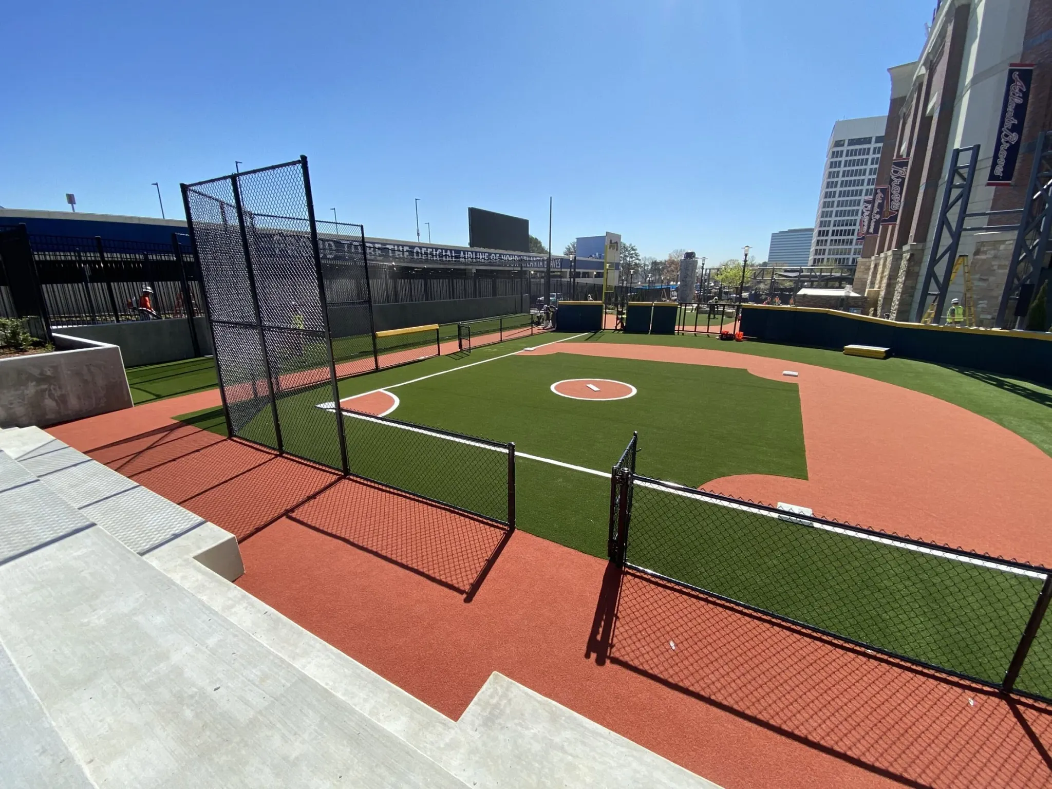 Outdoor baseball field with artificial turf and red track