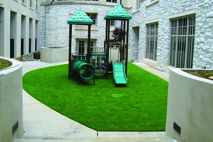 Durable artificial grass for outdoor play areas Playground with artificial grass in urban courtyard