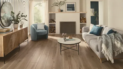 This COREtec product features Soft Step, our newest attached underlayment. large modern living room with fireplace, wood stacked on shelves, couch and large console with morror and large window, sun-filled room with light oak wood look vinyl flooring.