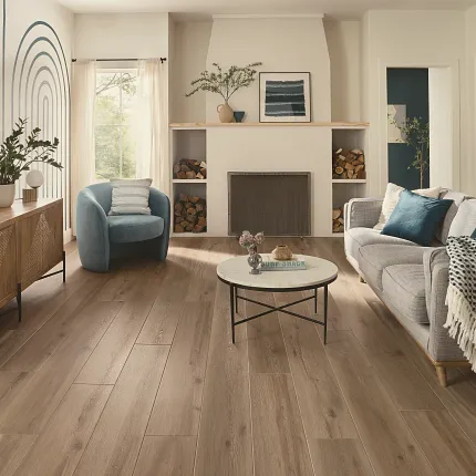 This COREtec product features Soft Step, our newest attached underlayment. large modern living room with fireplace, wood stacked on shelves, couch and large console with morror and large window, sun-filled room with light oak wood look vinyl flooring.