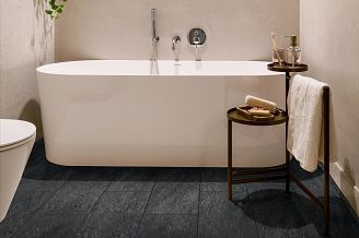 spa like bathroom with striking black coretec tile and deep soaker bathtub