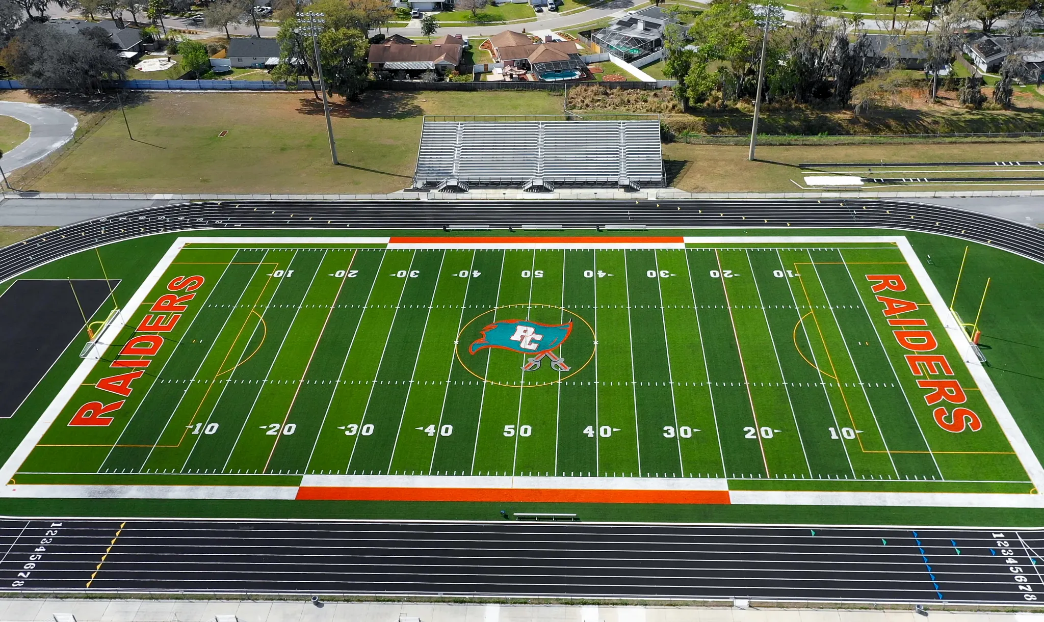 Aerial view of a football field with "Raiders" branding