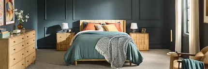 Comfortable and Stylish Carpet Flooring for a Cozy Bedroom Ambiance Cozy bedroom with plush carpet flooring, featuring a wooden bed with teal bedding and colorful pillows, surrounded by wooden furniture and soft lighting