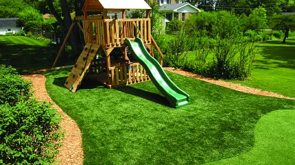 Durable artificial grass for outdoor play areas Playground with artificial grass in a backyard