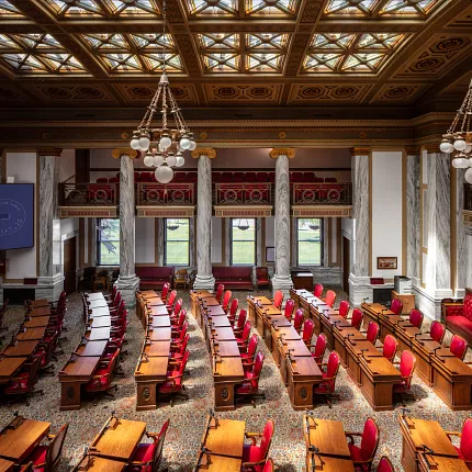 Elegant flooring in a historic government setting Ornate government facility with red chairs and wooden desks