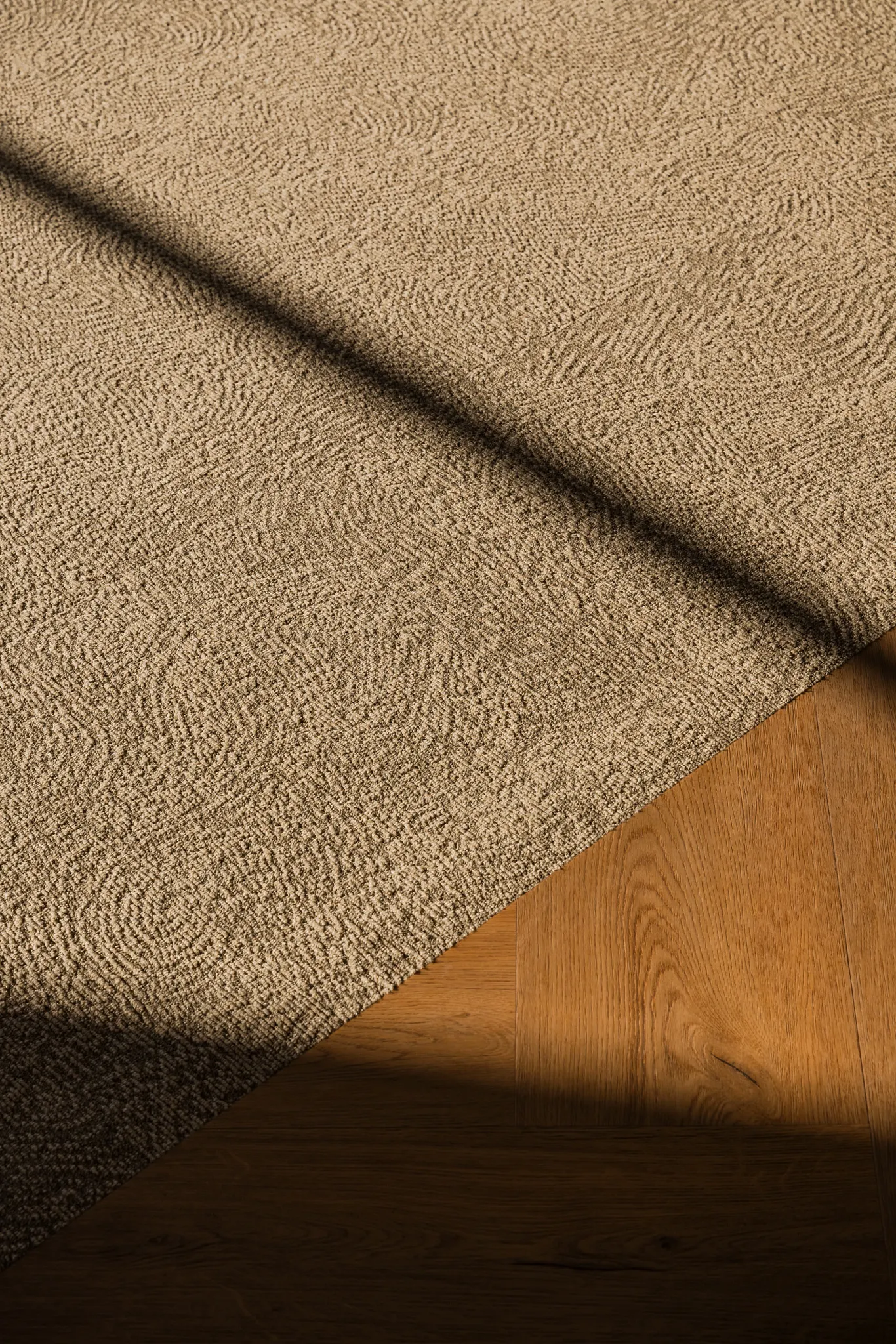 Close up carpet and rich wood herringbone floor from Coretec