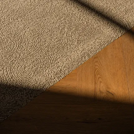 Close up carpet and rich wood herringbone floor from Coretec