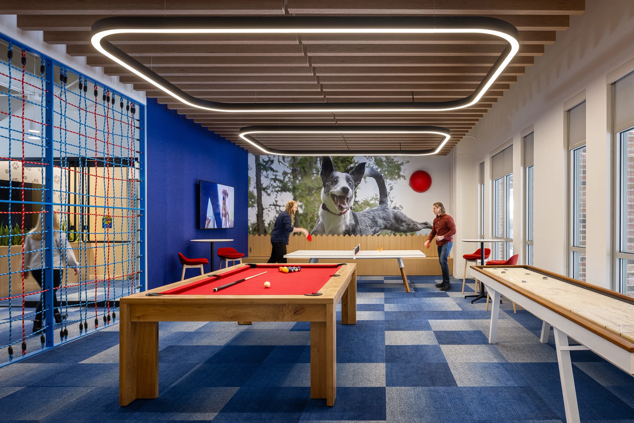 Modern game room with blue carpet tiles and wooden ceiling