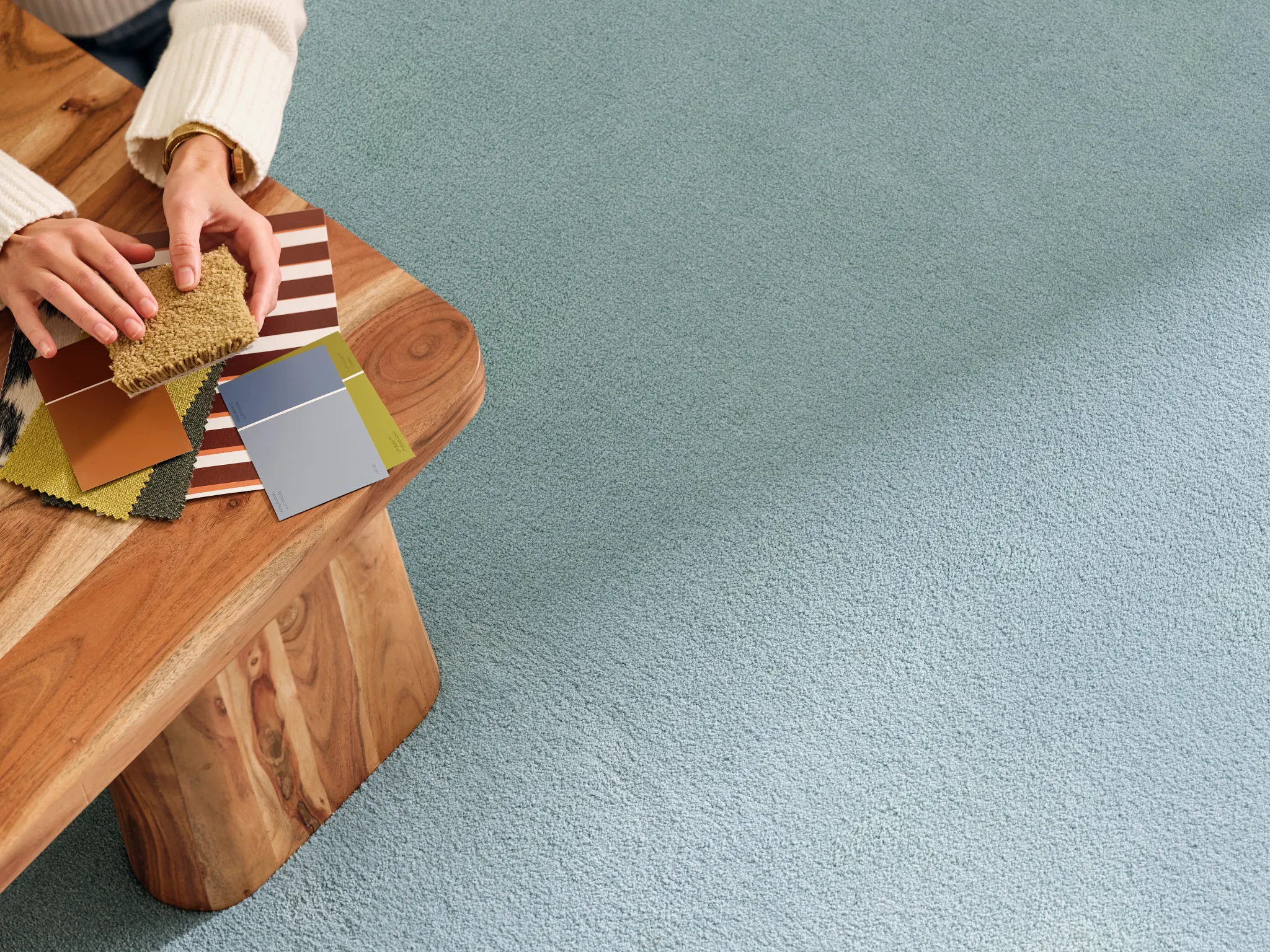 Light blue synthetic carpet with a wooden table and color swatches