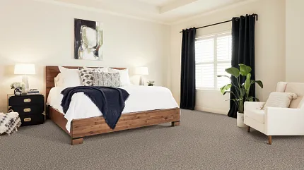 Comfortable and Durable Carpet Flooring in a Modern Bedroom Setting Cozy bedroom with neutral-toned carpet flooring, wooden bed frame, and modern decor