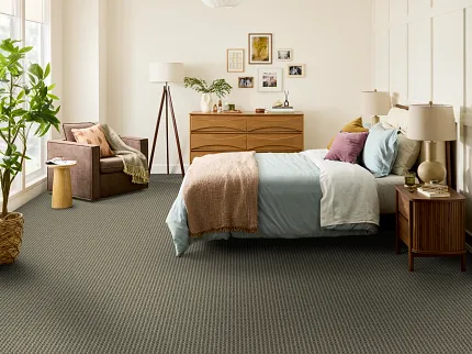 Textured Blue Carpet in a Cozy Living Room Setting Cozy living room with a plush cream armchair and a wooden side table on a textured blue carpet