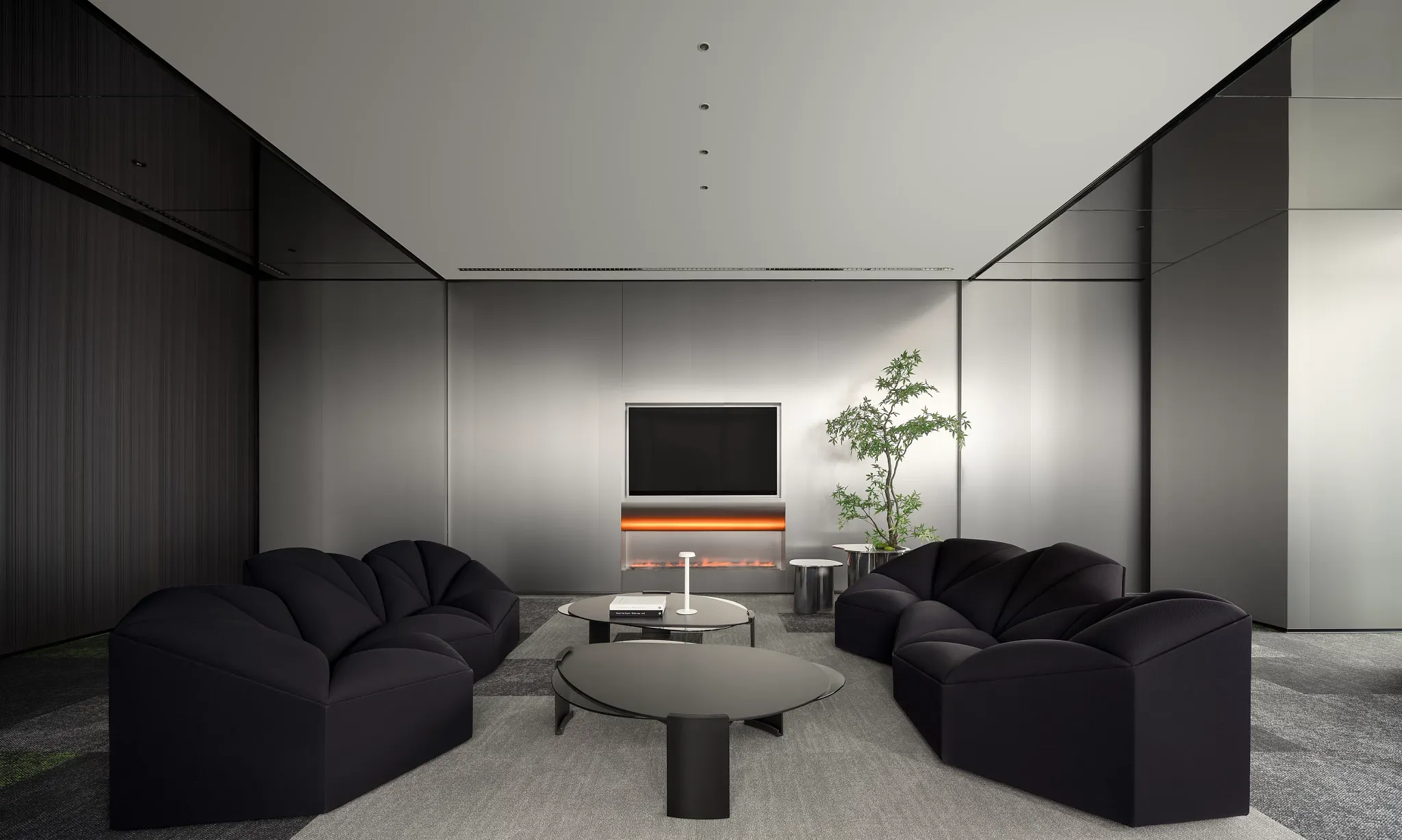 Modern living room with sleek black sofas and contemporary flooring