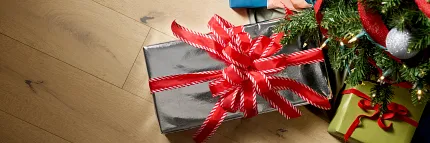 Durable hardwood flooring for festive home comfort Hardwood flooring with Christmas gifts under a tree