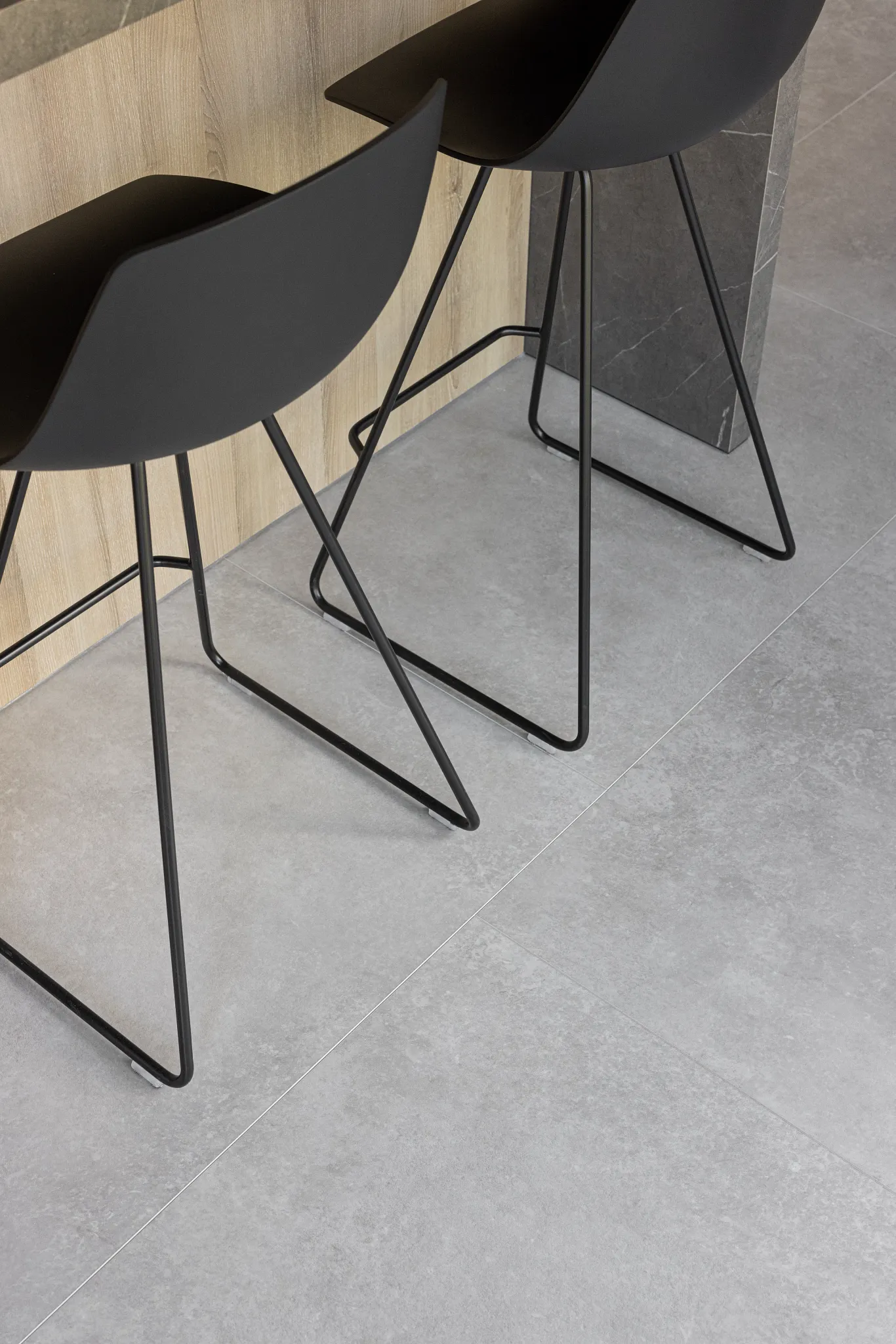 Concrete Coretec floor with black modern chairs