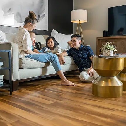 Wood Look Luxury Vinyl Plank Flooring in Modern Living Room Scene Modern living room with wood look luxury vinyl plank flooring, featuring a family relaxing on a sofa