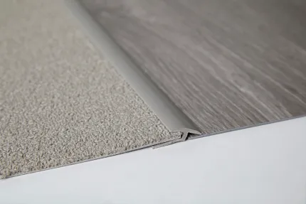 Beige Carpet Tile and Gray LVP Flooring Transition Detail Close-up of a transition between beige commercial carpet tile and gray commercial LVP flooring