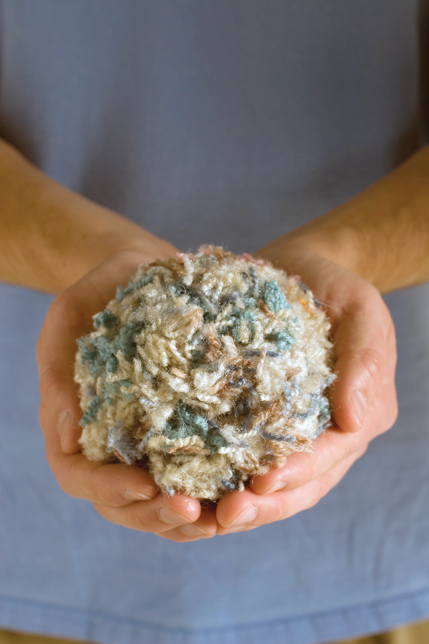 Hand holding recycled carpet fibers