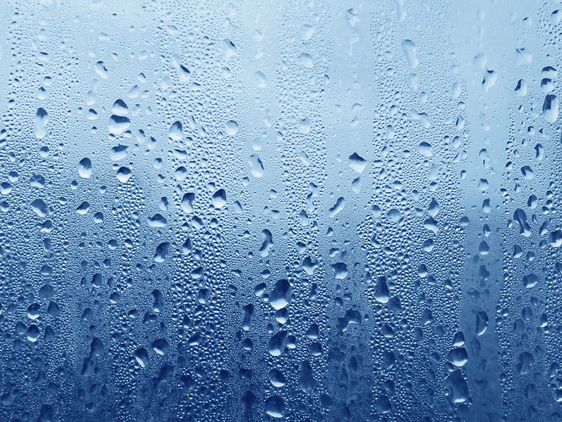 Blue water droplets on glass surface