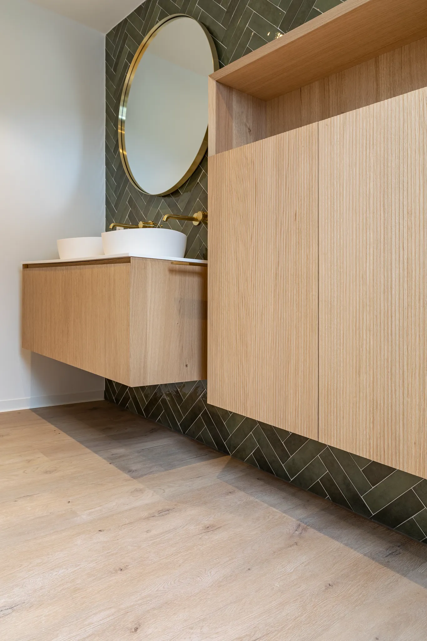 Country bathroom with green herringbone tile and Coretec light wooden plank floors