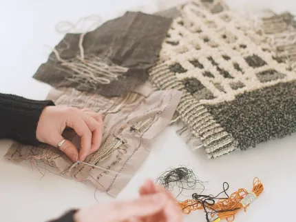 Textile sample creation with diverse textures and colors Close-up of hands working on textile samples with various textures and colors