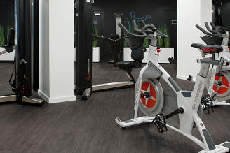 A gym with stationary bikes and exercise equipment on COREtec vinyl flooring.