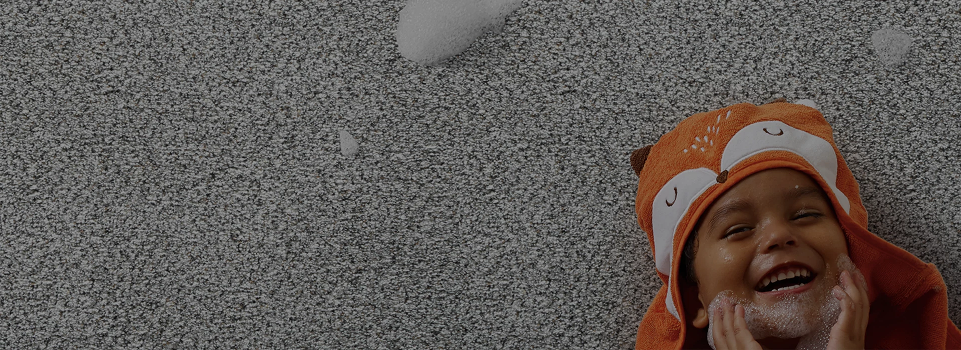 Multicolored carpet floor with a happy child laying on it