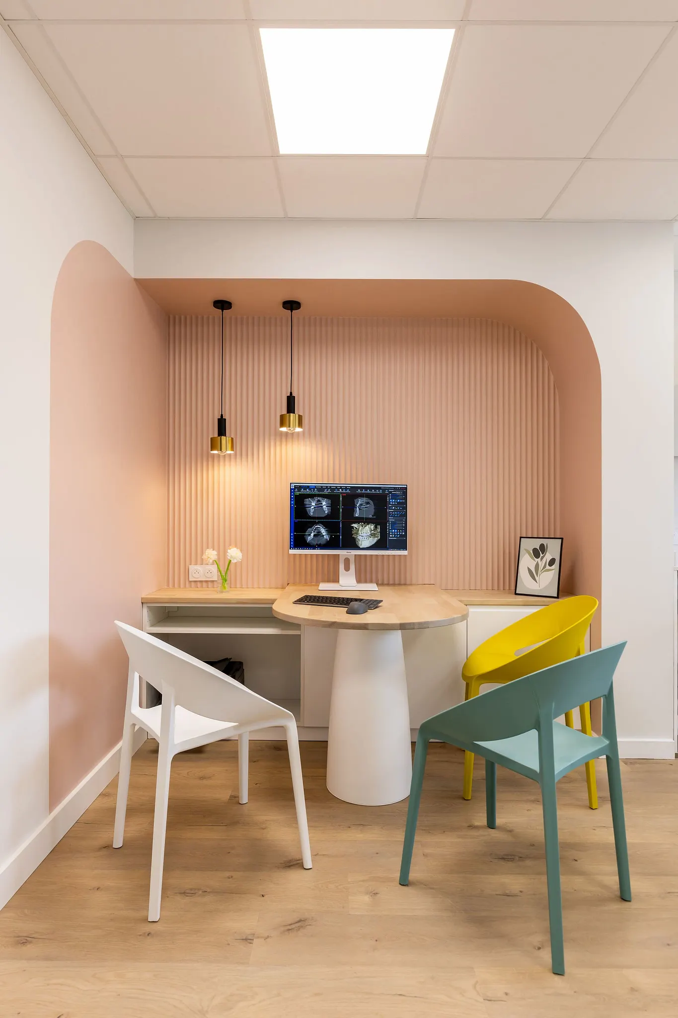 Modern office space with light wood flooring and colorful chairs