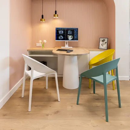 Modern office space with light wood flooring and colorful chairs