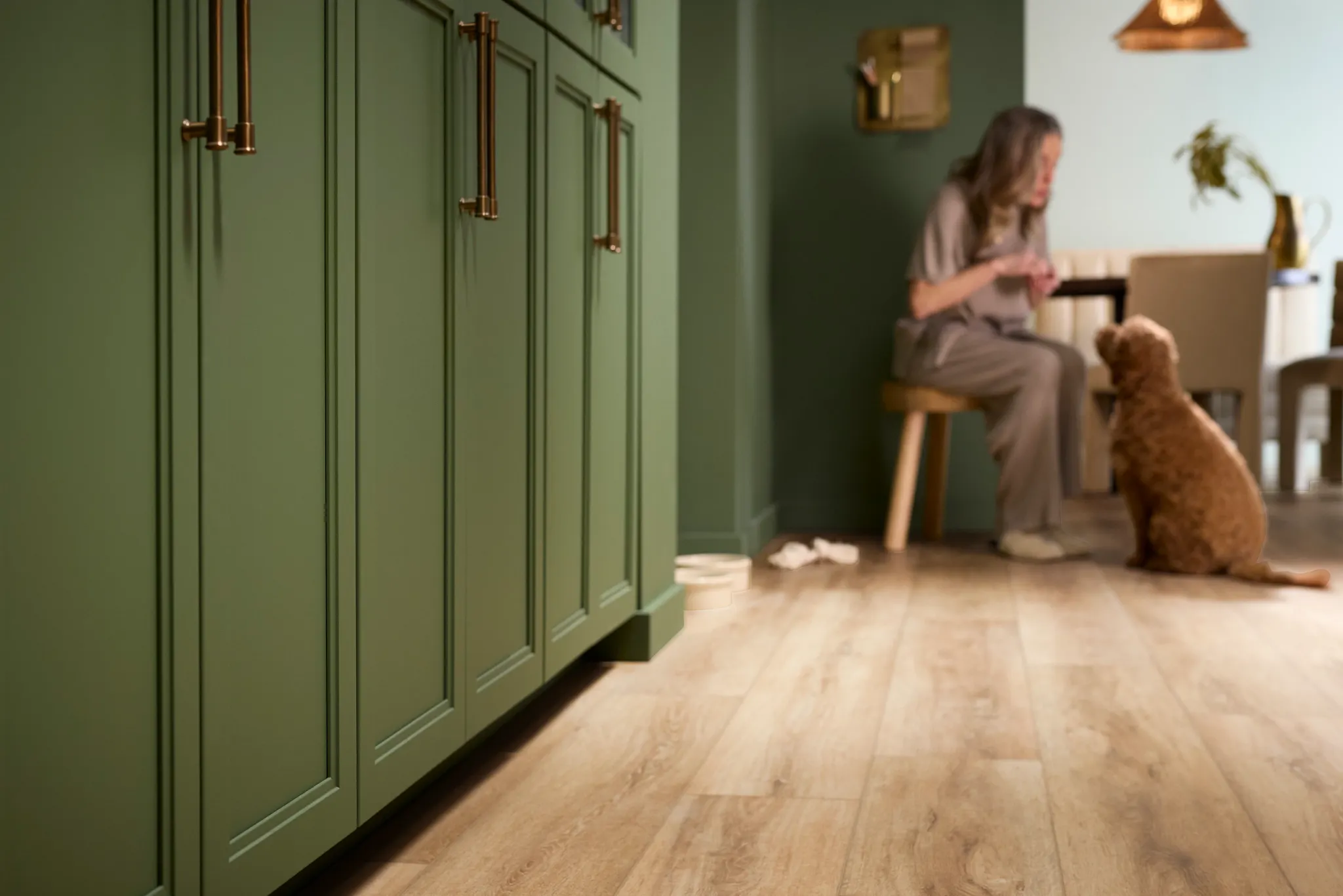 Coretec Residential WPC vinyl flooring in a modern kitchen with green cabinets