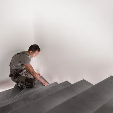 Grey Luxury Vinyl Flooring Installation on Stairs - Durable and Waterproof Professional installing grey luxury vinyl flooring on stairs