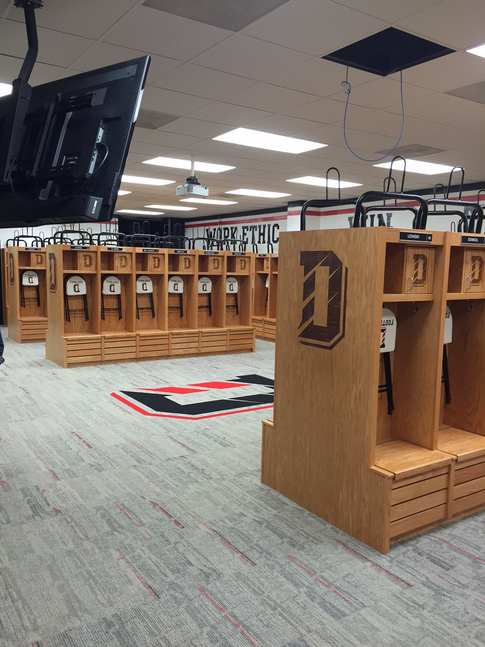
  "Modern locker room with light gray and red commercial carpet flooring"
)